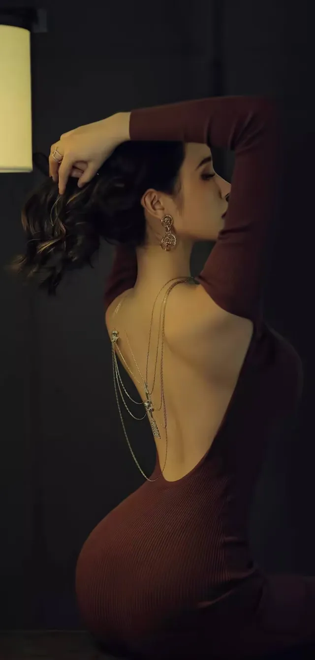 美女穿酒红露背长裙戴金链饰品侧身撩发美女手机壁纸