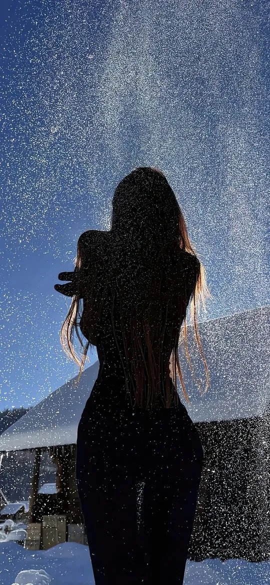 雪中长发女子背影洒水瞬间手机壁纸