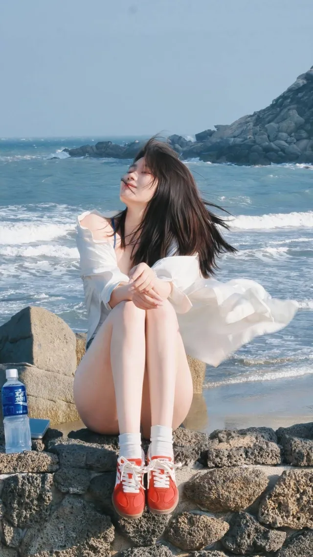 礁石海风闭眼白衬衫美女手机壁纸