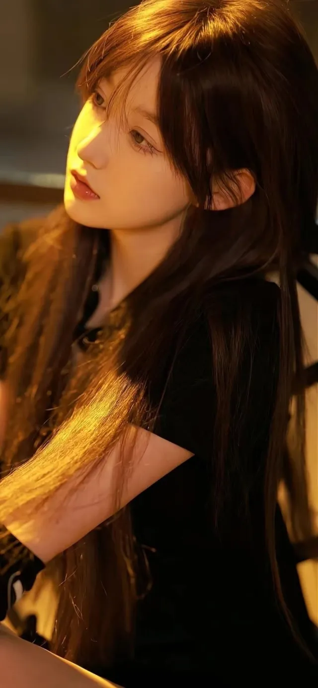 暖光侧颜长发少女温柔凝视手机壁纸