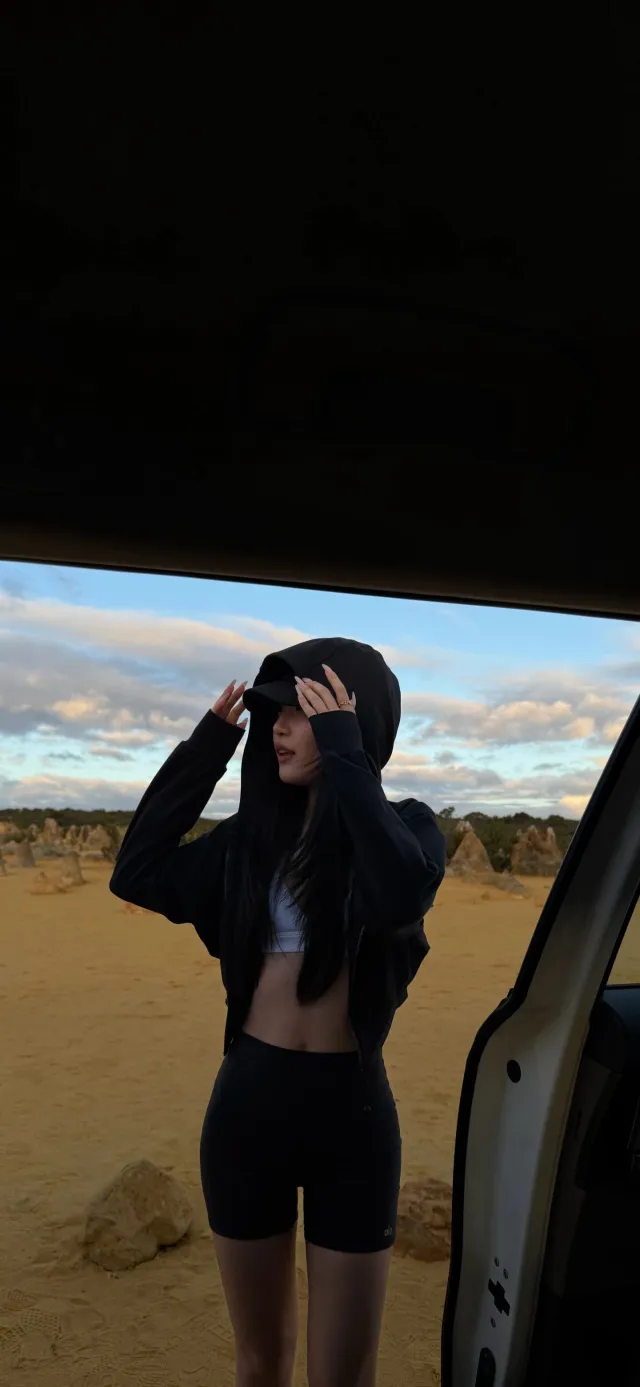 美女沙漠车旁戴帽调整动作户外摄影手机壁纸