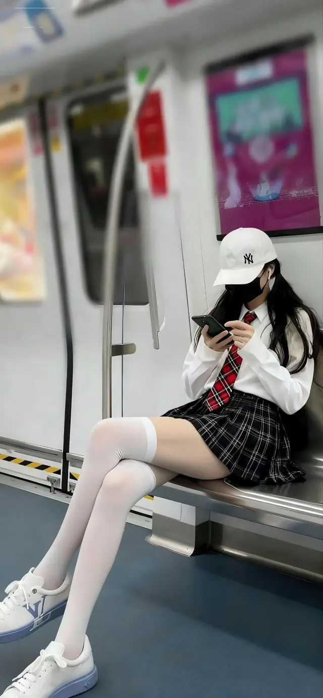 地铁车厢女子JK制服格子裙低头看手机人物手机壁纸