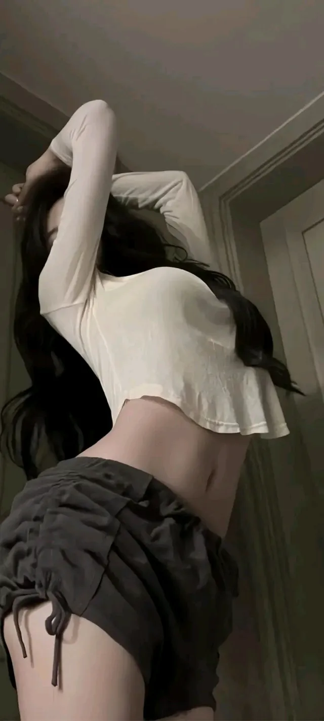 黑发女子白色短款上衣黑色褶皱短裤侧身抬手手机壁纸