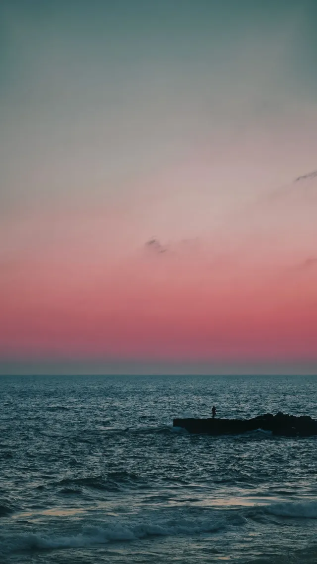 海边日落剪影人物粉紫风景手机壁纸