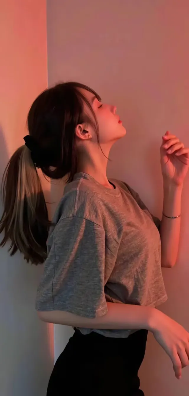 灰色短T恤配黑裤马尾美女靠墙仰头摄影手机壁纸