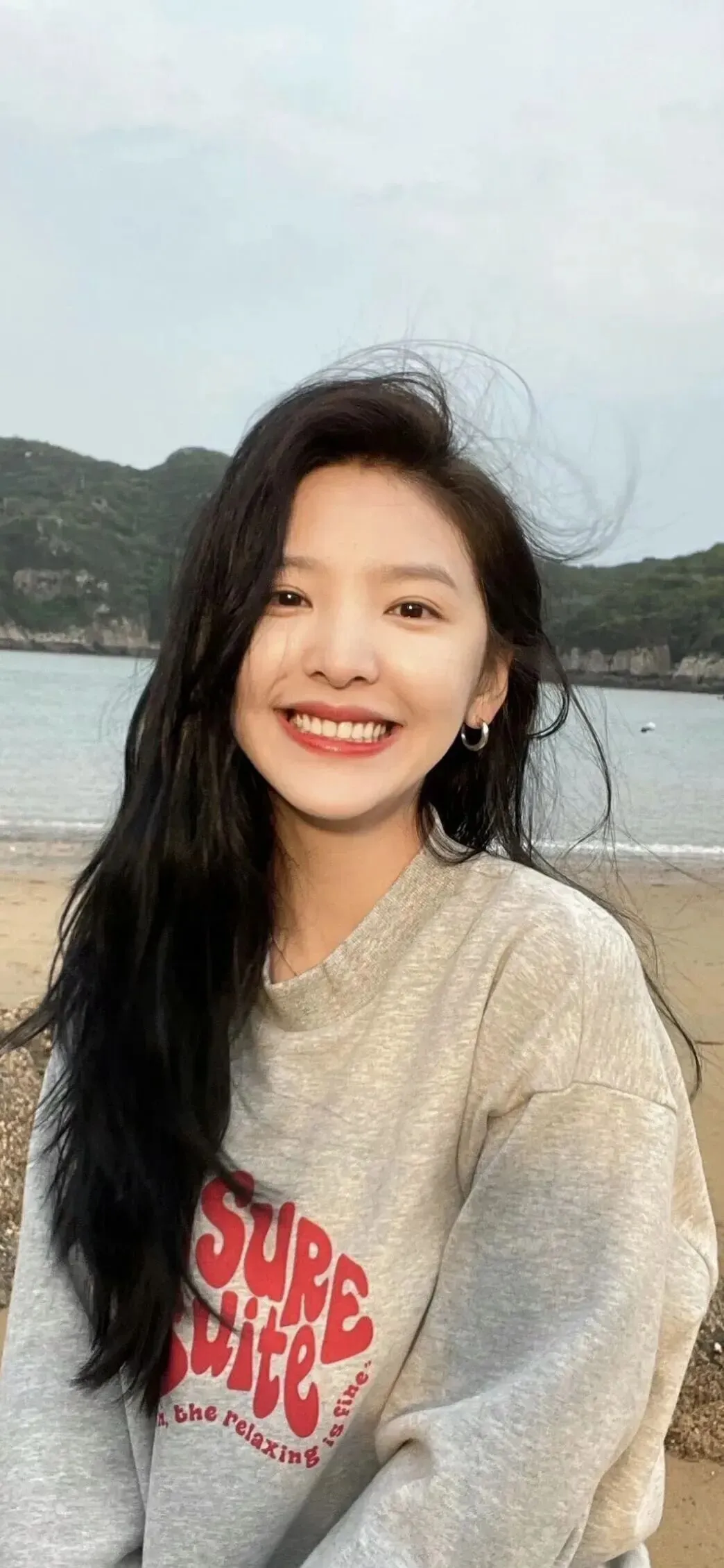 海边灰卫衣笑容治愈清新美女手机壁纸
