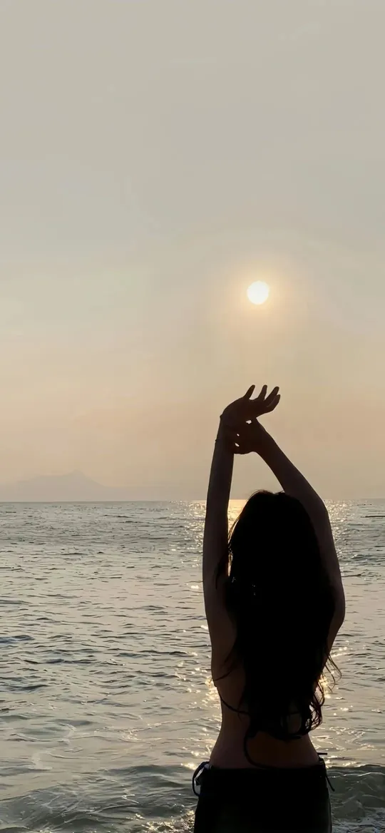 海边日落女子举手剪影手机壁纸