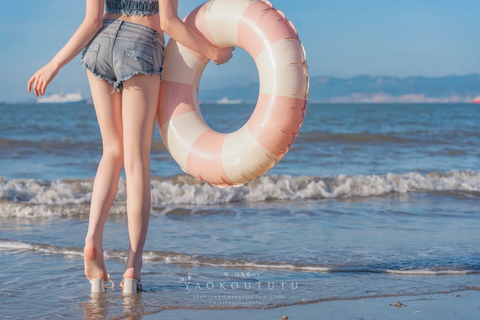 咬一口兔娘ovo站在海边穿着牛仔短裤手拿游泳圈露出两条洁白美腿