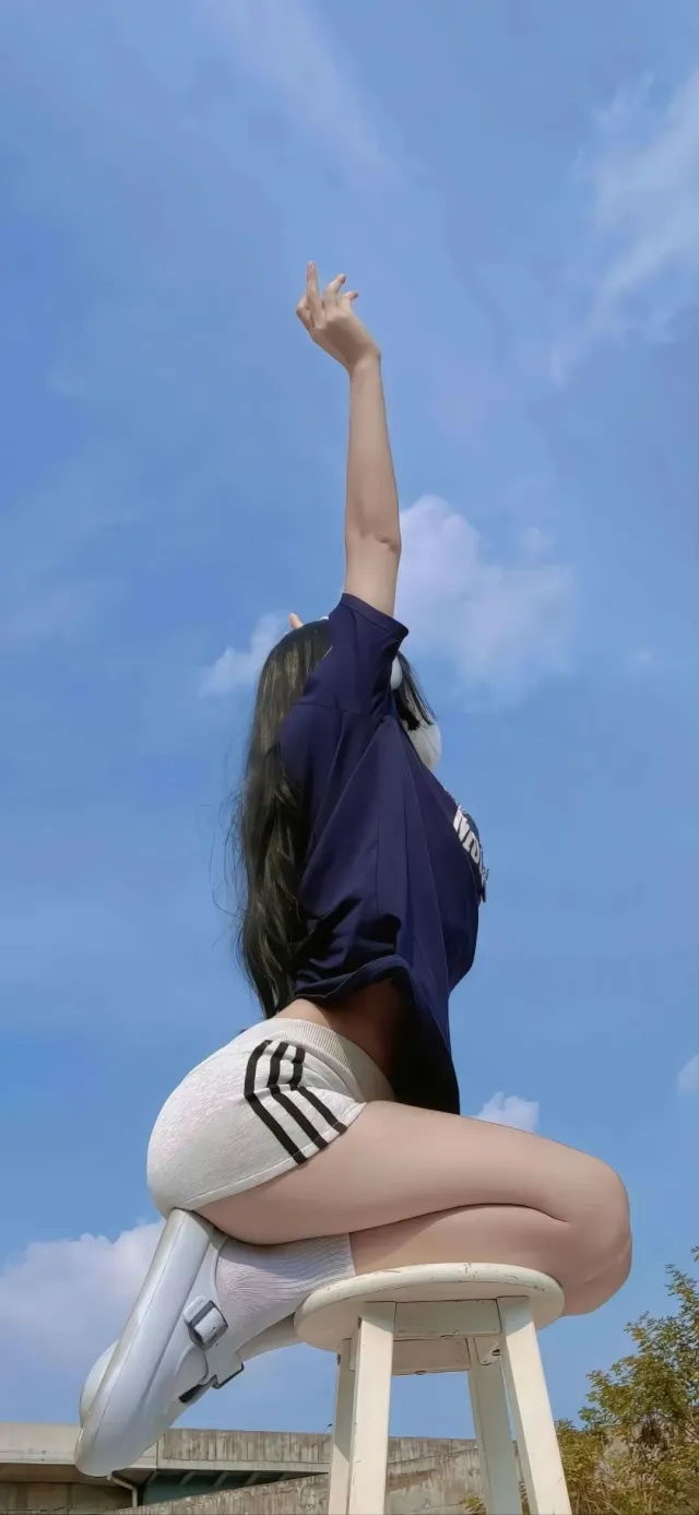 少女蓝T恤白短裤高举手臂坐凳子手机壁纸